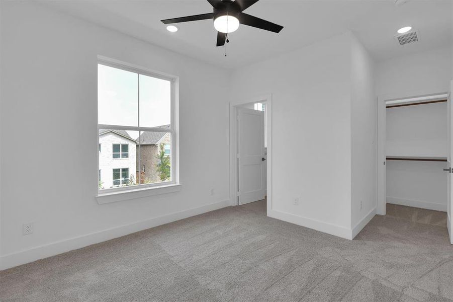 Unfurnished bedroom featuring carpet flooring, a spacious closet, ceiling fan, and recessed lighting Unfurnished bedroom featuring carpet flooring, a spacious closet, ceiling fan, and recessed lighting
