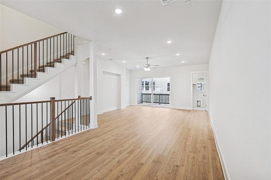 Unfurnished living room with light wood-style flooring, a ceiling fan, and recessed lighting