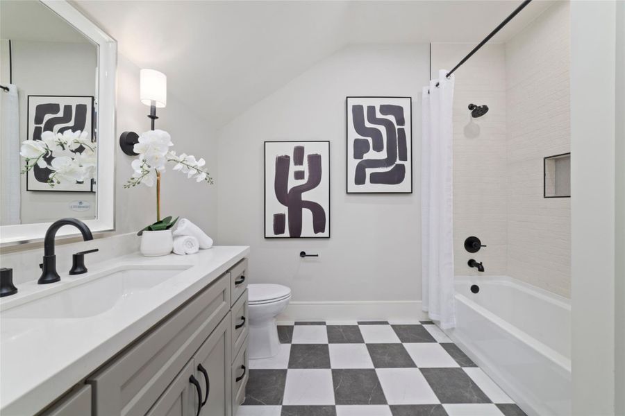 The third bathroom upstairs has a tub and shower combo with tile surround.