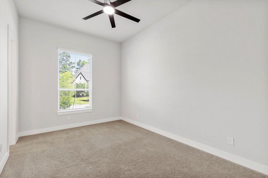 Light-filled bedroom with plush carpet, crisp walls, and modern ceiling fan for year-round comfort.