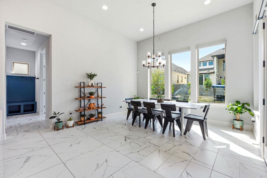 A well-lit dining area featuring high ceilings and sleek tile flooring. A well-lit dining area featuring high ceilings and sleek tile flooring.