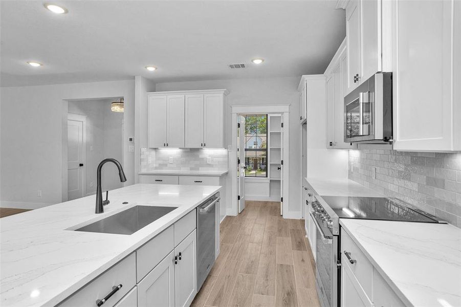 View of kitchen looking toward coffee bar area and large walkin pantry.