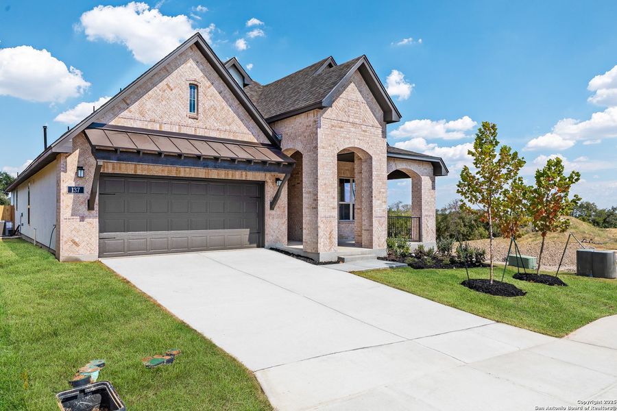 Front exterior of a new home in The Enclave at Potranco Oaks, Castroville, TX, highlighting curb appeal (Image 1).