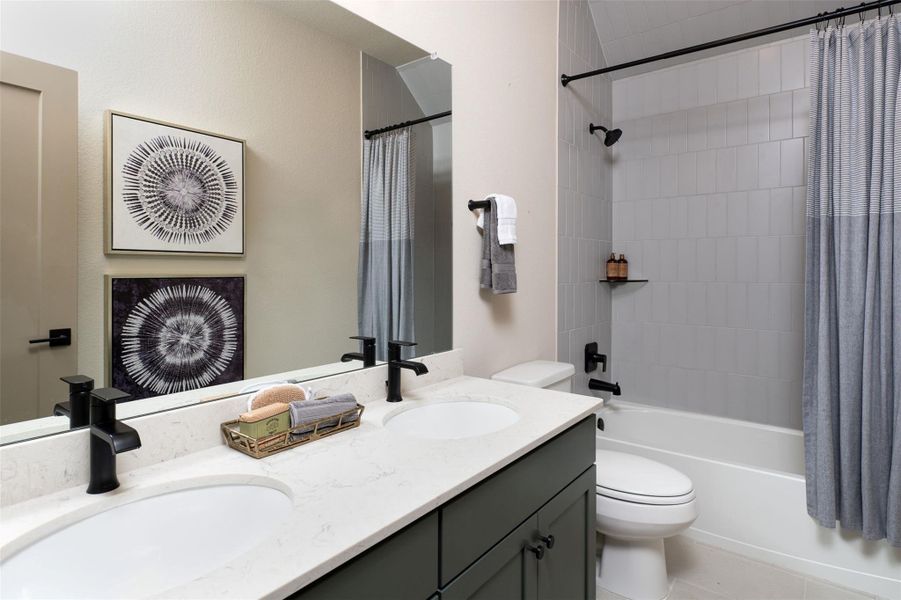 The secondary bath features tile flooring, white cabinetry and light countertops and a shower/tub combo. Perfect for accommodating any visiting family and friends.