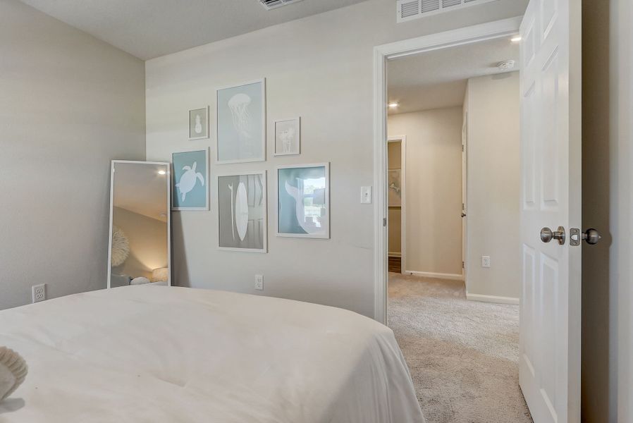 A bedroom with a mirror and a bed.