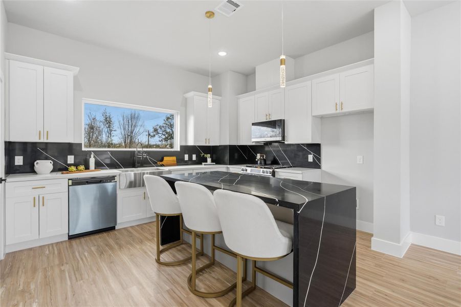 Modern kitchen with oversized island, quartz countertops, and ample cabinetry.Open layout designed for everyday living and entertaining.Designed for both entertaining and everyday living with sleek finishes throughout.
