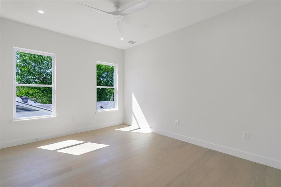 Unfurnished room with light wood-type flooring, a ceiling fan, visible vents, recessed lighting, and baseboards