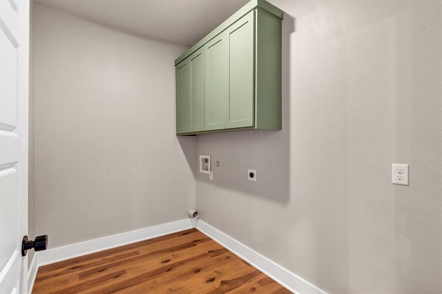 Laundry area featuring hookup for an electric dryer, cabinet space, dark wood-type flooring, and washer hookup