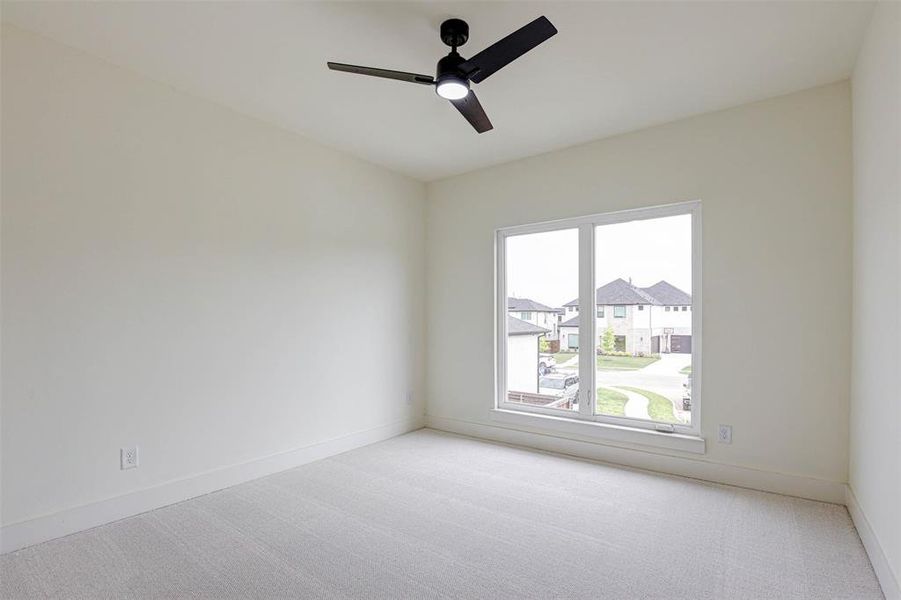 Empty room with light carpet and a ceiling fan