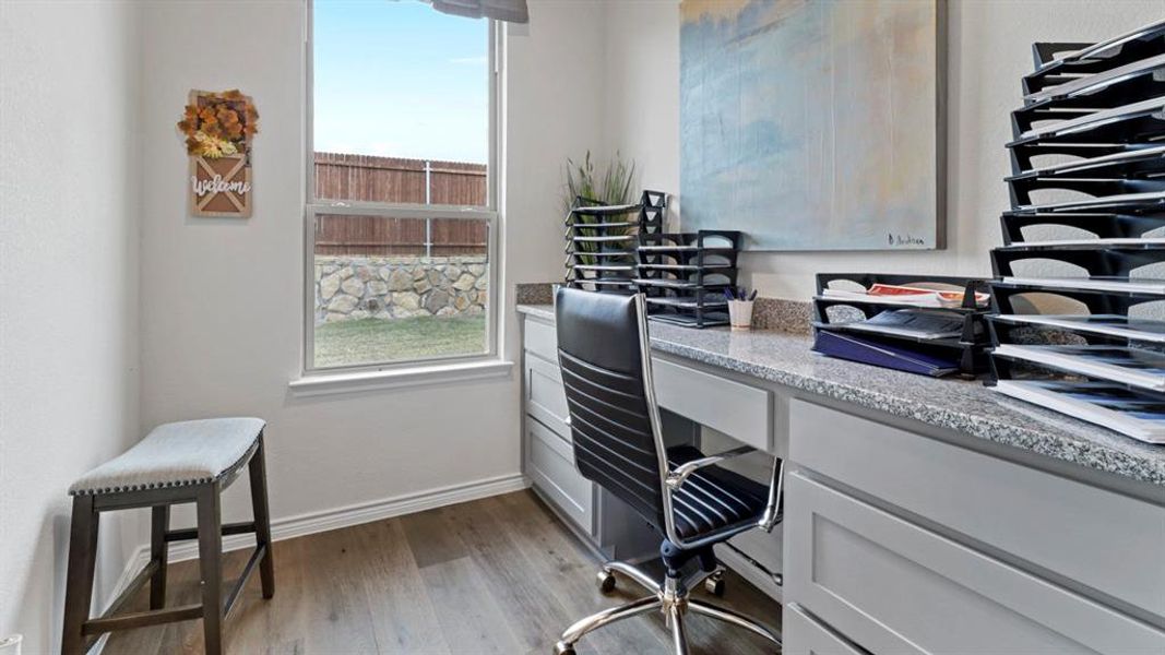 Office featuring built in desk and dark wood-type flooring