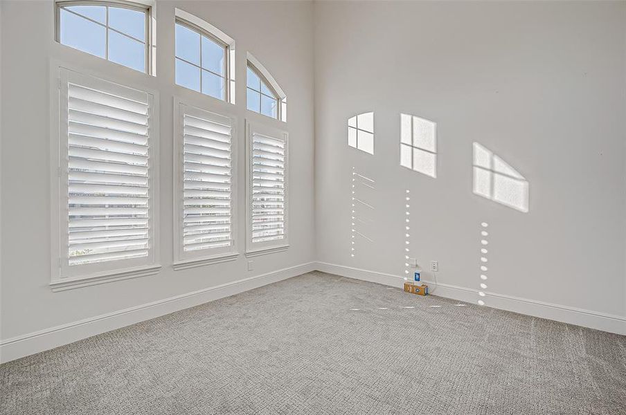 Home Office: Situated at the front of the home, this refined space features double glass doors, high ceilings, and classy plantation shutters providing ample natural light with views of the beautifully landscaped front yard.