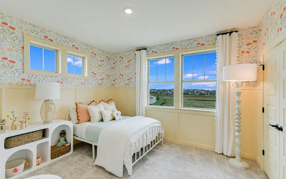 Bedroom featuring wallpapered walls, wainscoting, and carpet flooring