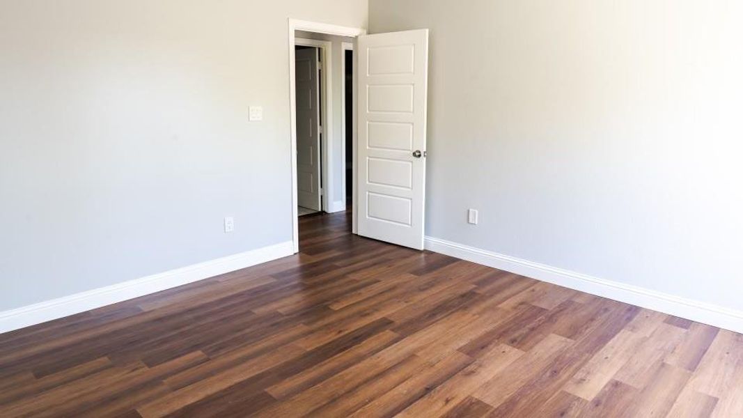 Unfurnished room with dark hardwood / wood-style floors Unfurnished room with dark hardwood / wood-style floors