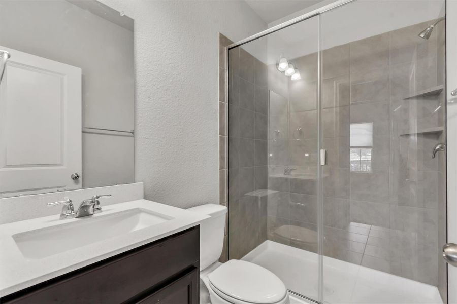 A well-appointed bathroom offers a convenient walk-in shower and ample vanity space.