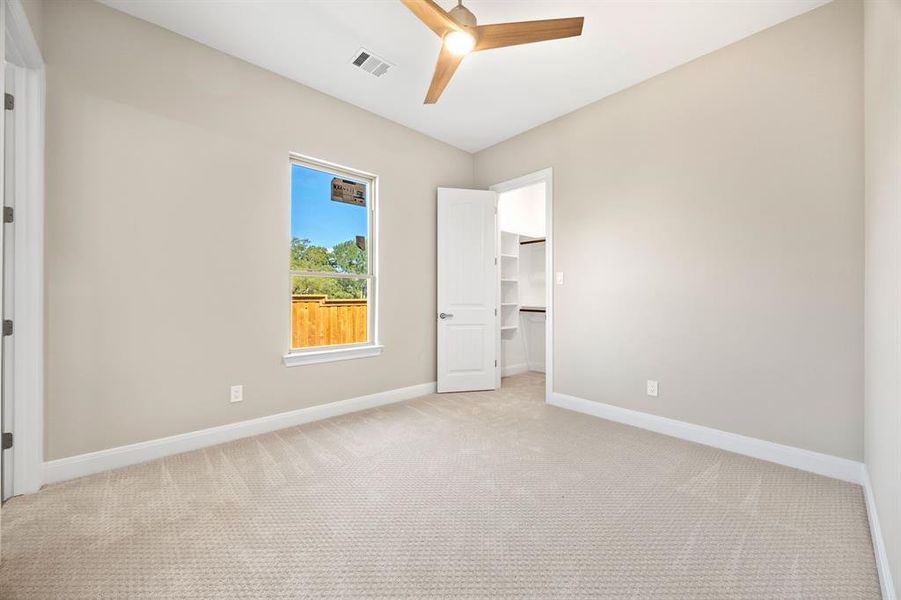 Unfurnished bedroom with ceiling fan, light carpet, a spacious closet, and a closet