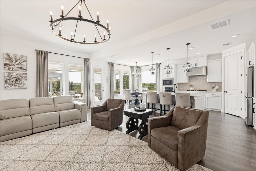 An open floor plan seamlessly connects the living room, dining area, and modern kitchen spaces.