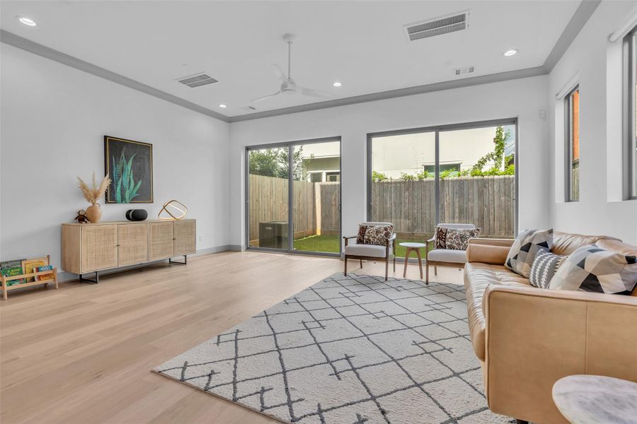 Another view of the living room highlights the natural light coming through the glass doors, which provide a connection to the outdoor space and brighten the room.
