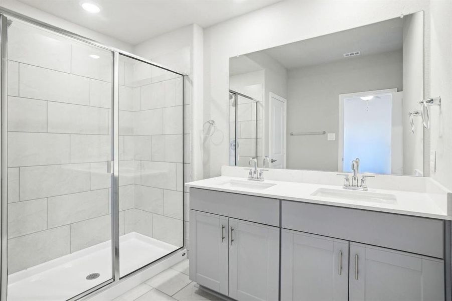 Full bath with a shower stall, double vanity, and light tile patterned floors Full bath with a shower stall, double vanity, and light tile patterned floors