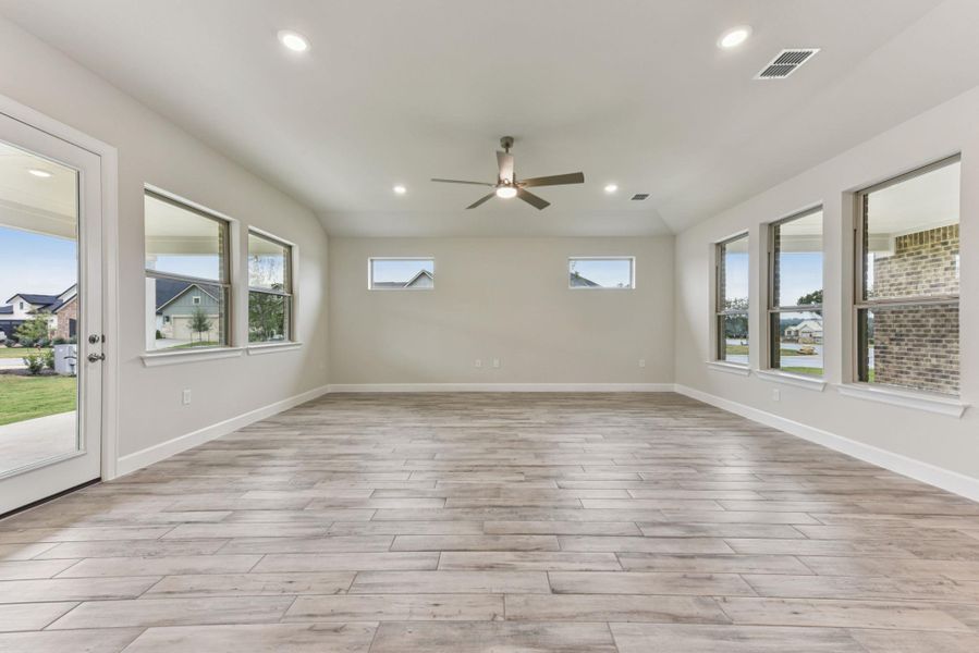 Unfurnished room with wood finish floors, healthy amount of natural light, recessed lighting, lofted ceiling, and ceiling fan