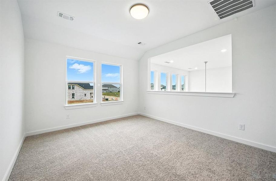 Spare room featuring light carpet and plenty of natural light Spare room featuring light carpet and plenty of natural light