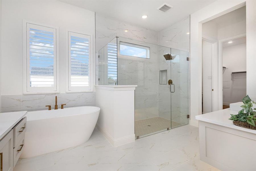 Bathroom featuring vanity, light marble finish flooring, a soaking tub, a marble finish shower, and recessed lighting