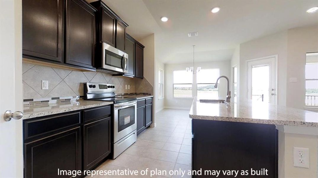 Kitchen with appliances with stainless steel finishes, light stone counters, decorative backsplash, recessed lighting, and hanging light fixtures Kitchen with appliances with stainless steel finishes, light stone counters, decorative backsplash, recessed lighting, and hanging light fixtures