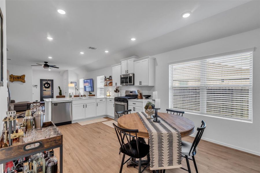 A view of open concept dining area, kitchen, large peninsula, and family room.