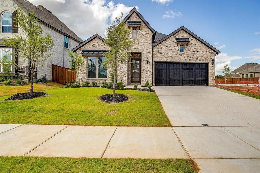 View of front of home featuring a garage and a front yard