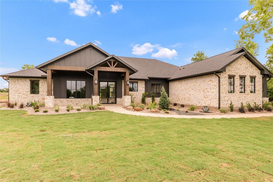 Craftsman house featuring a front lawn, stone siding, covered porch, french doors, and a shingled roof