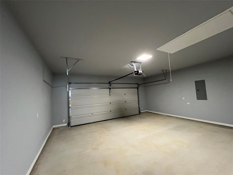 Garage with electric panel and a garage door opener