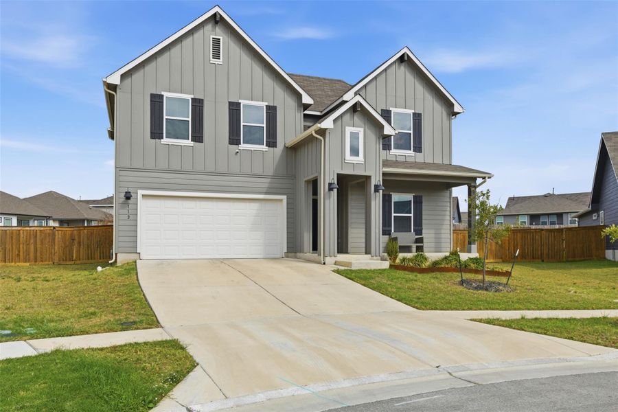 View of front of house featuring board and batten siding, a garage, and concrete driveway