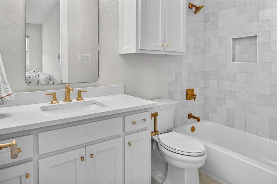Full bathroom featuring tub / shower combination, vanity, and a textured wall
