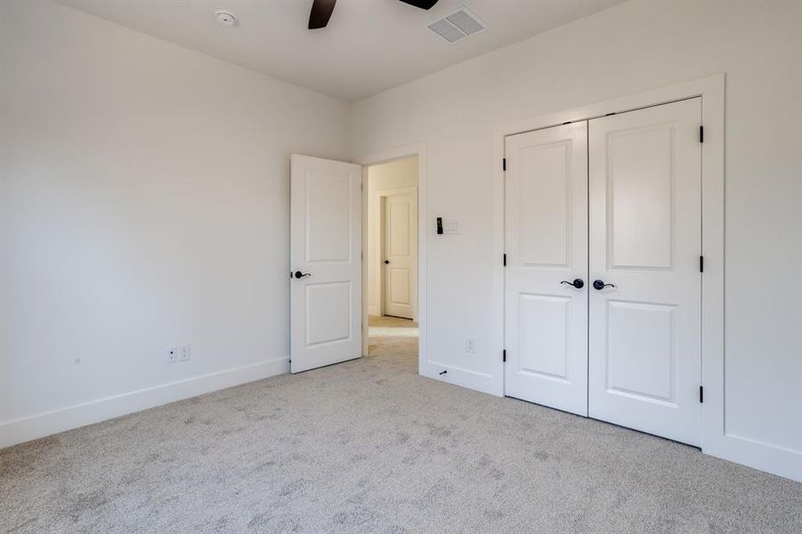 Unfurnished bedroom featuring carpet, a ceiling fan, and a closet