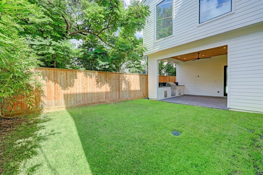 Covered outdoor kitchen with grill & pool-sized backyard with bamboo landscape for privacy