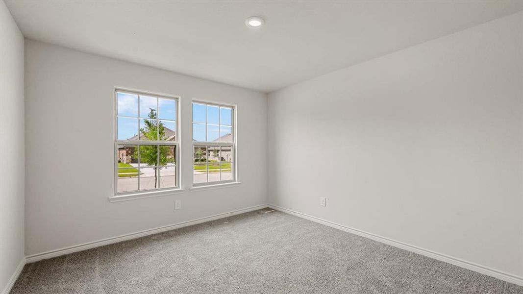 Light-filled interior space featuring two large paneled windows, neutral wall paint, recessed lighting, and grey carpeting Light-filled interior space featuring two large paneled windows, neutral wall paint, recessed lighting, and grey carpeting