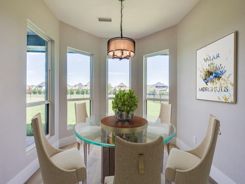 Virtual Staged Dining room with a chandelier, baseboards, healthy amount of natural light, and wood finished floors