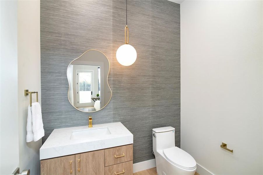 Bathroom featuring vanity, toilet, and tile walls