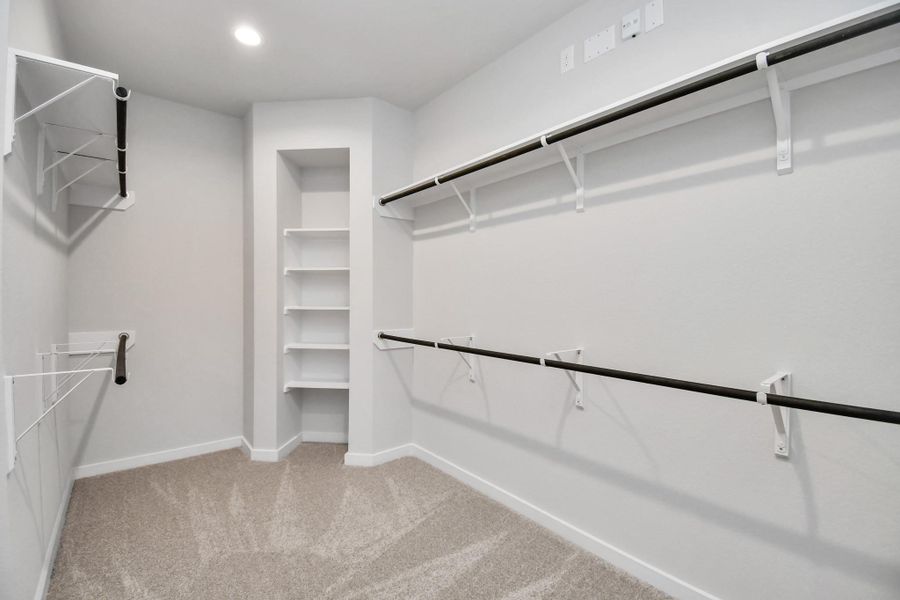 Walk-in closet that epitomizes luxury and practicality. This generously sized space features built-in shelving, offering abundant room for impeccable organization. High ceilings and recessed lighting create a bright and welcoming ambiance. Walk-in closet that epitomizes luxury and practicality. This generously sized space features built-in shelving, offering abundant room for impeccable organization. High ceilings and recessed lighting create a bright and welcoming ambiance.