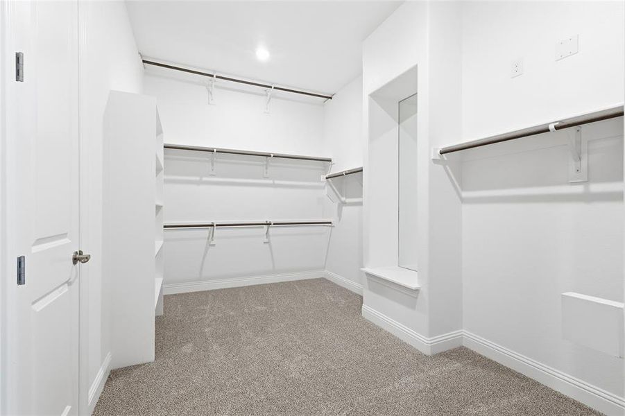 Walk in closet featuring light carpet Walk in closet featuring light carpet