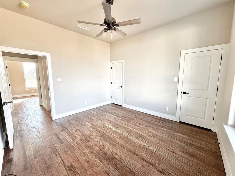 Unfurnished bedroom with wood finished floors and ceiling fan Unfurnished bedroom with wood finished floors and ceiling fan
