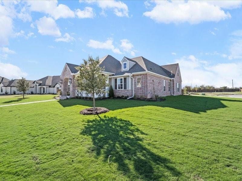 View of front of home with a front yard and brick siding