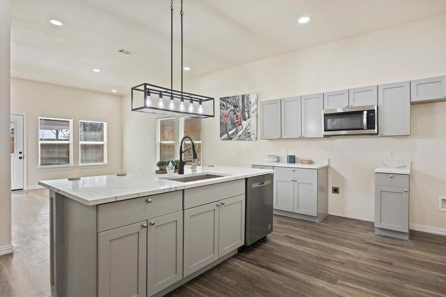 Kitchen with appliances with stainless steel finishes, gray cabinets, and sink