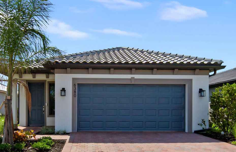 Front exterior of a new home in Del Webb Naples, Ave Maria, FL, highlighting curb appeal (Image 16). Front exterior of a new home in Del Webb Naples, Ave Maria, FL, highlighting curb appeal (Image 16).