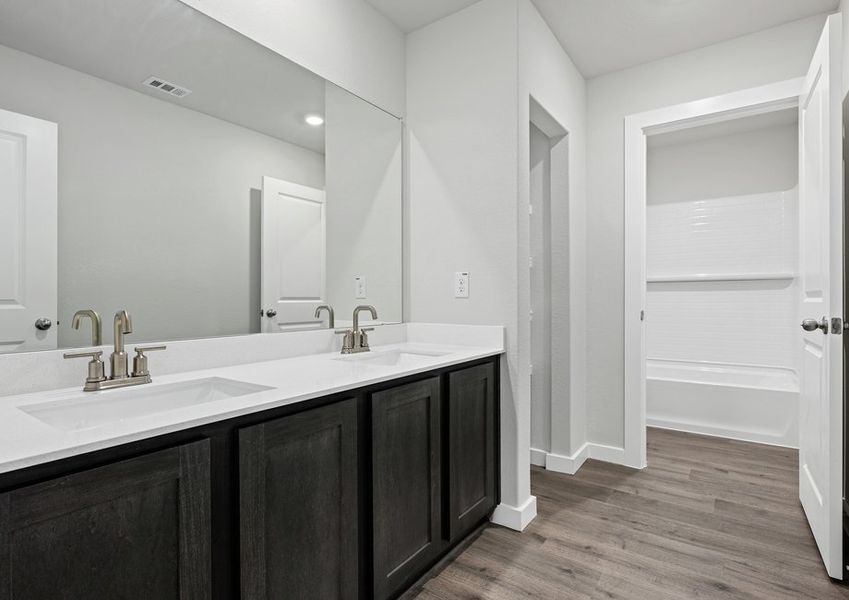 The secondary bathroom has a vanity space and a shower-tub combo.