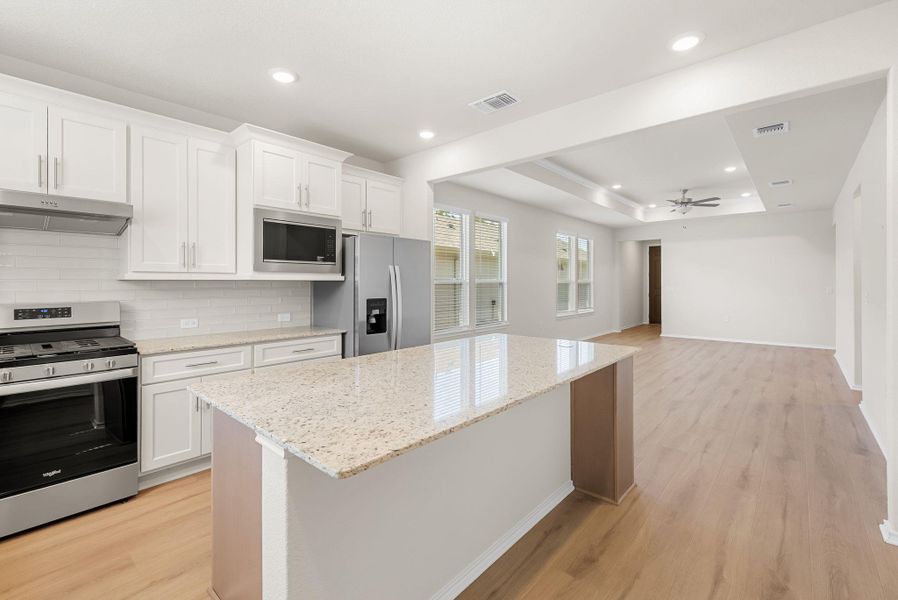 A well-lit kitchen with granite countertops seamlessly opens to a spacious living area, ideal for entertaining. A well-lit kitchen with granite countertops seamlessly opens to a spacious living area, ideal for entertaining.