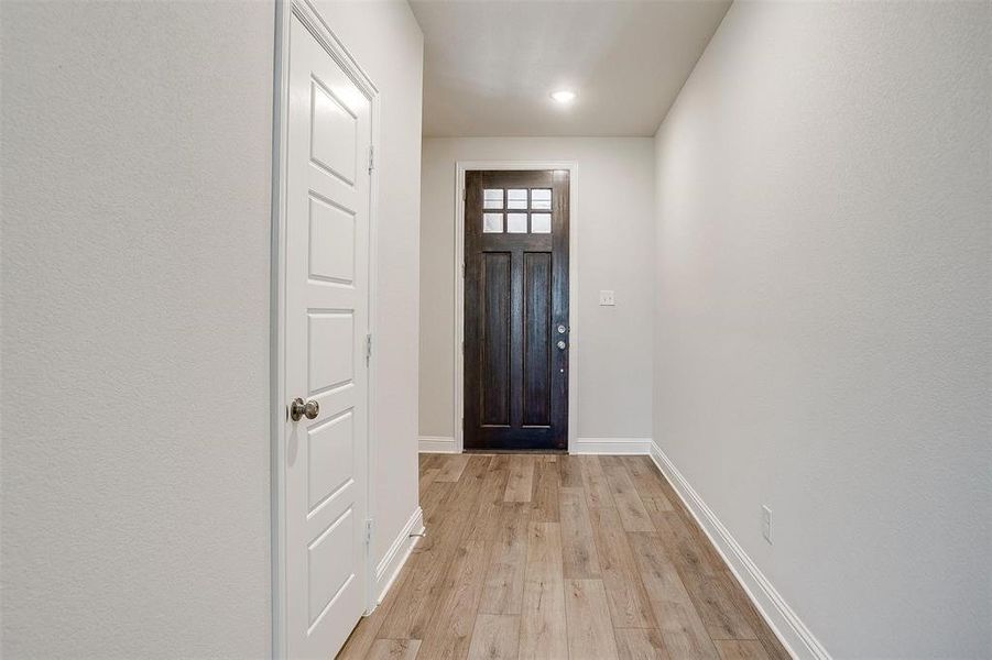 Doorway to outside featuring light wood finished floors and baseboards