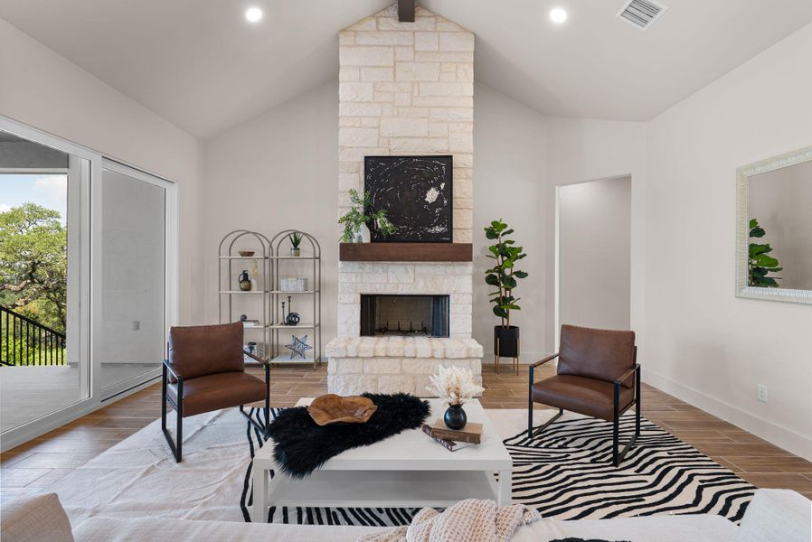 An inviting living area with high vaulted ceilings and a floor-to-ceiling stone fireplace, perfect for gathering.