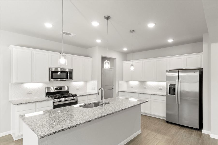 Kitchen with stainless steel appliances, a sink, decorative backsplash, light wood-type flooring, and recessed lighting