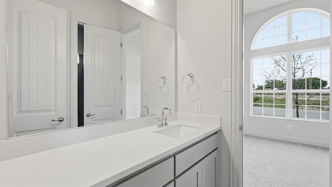 Bathroom vanity featuring a single basin sink and a stone-finish countertop