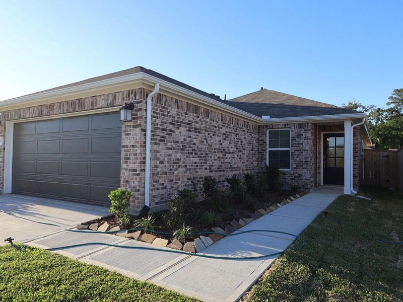 Front exterior of a new home in Pinewood at Grand Texas, New Caney, TX, highlighting curb appeal (Image 17).